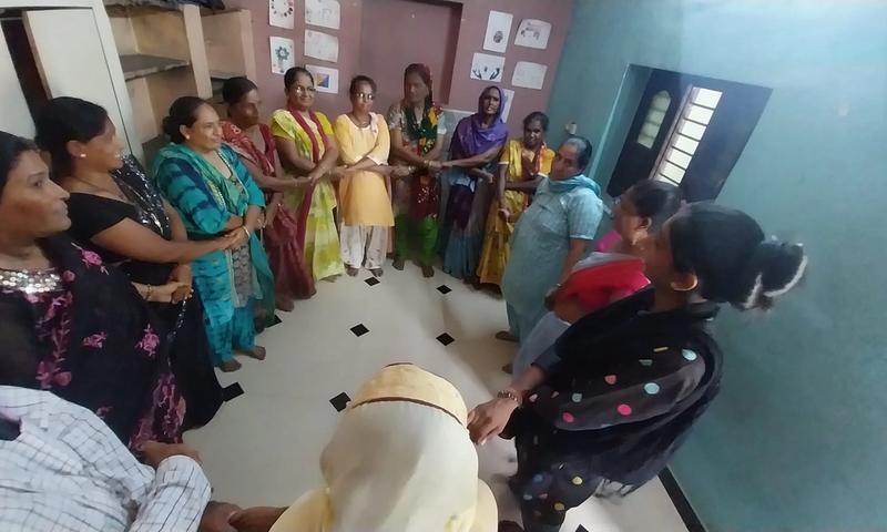 A group of women standing indoors in a circle