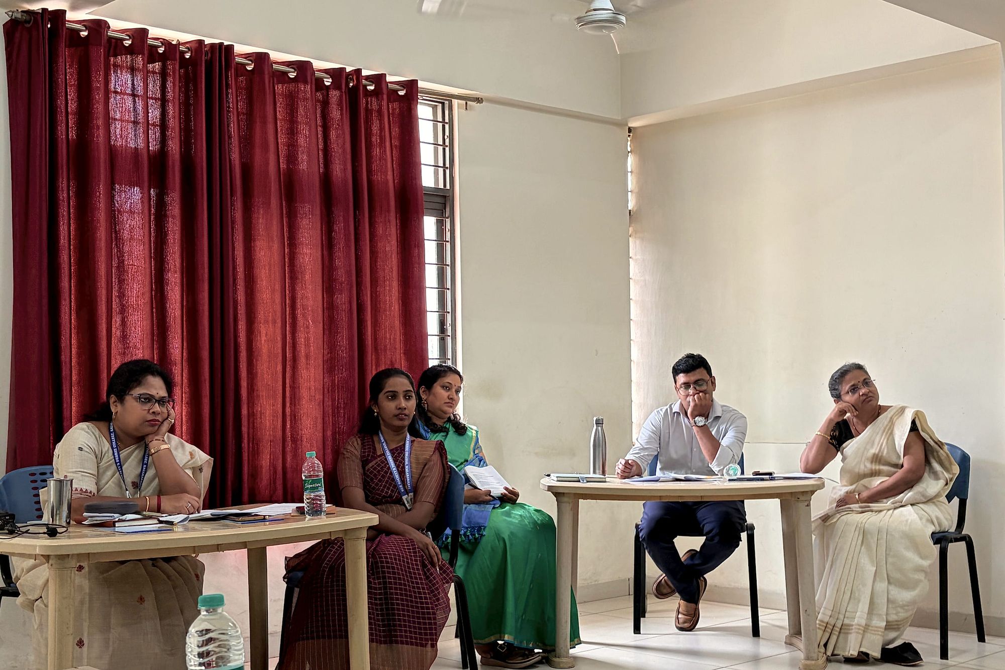 Participants seated at tables listen during a session.