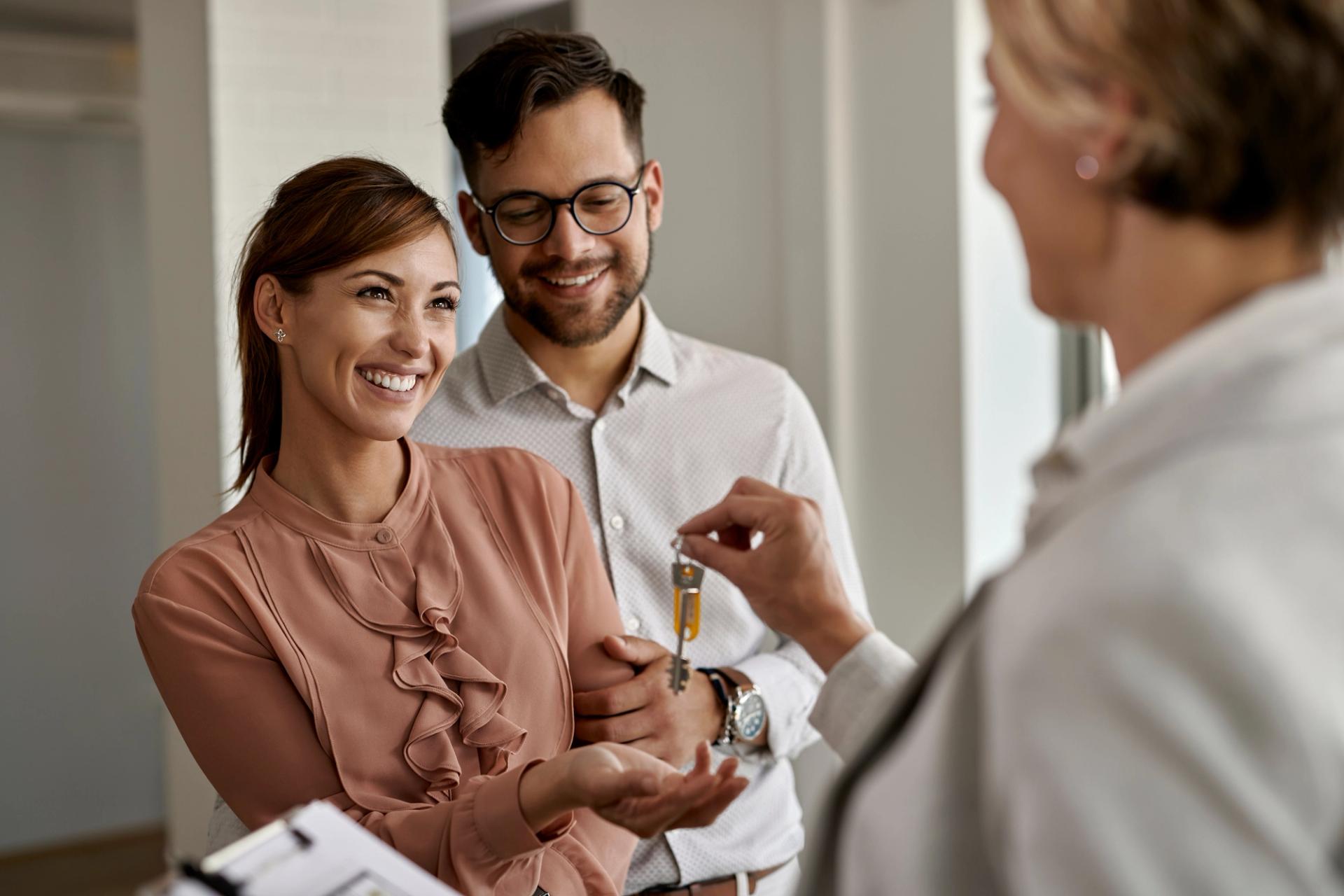 Woman and man being handed keys of home