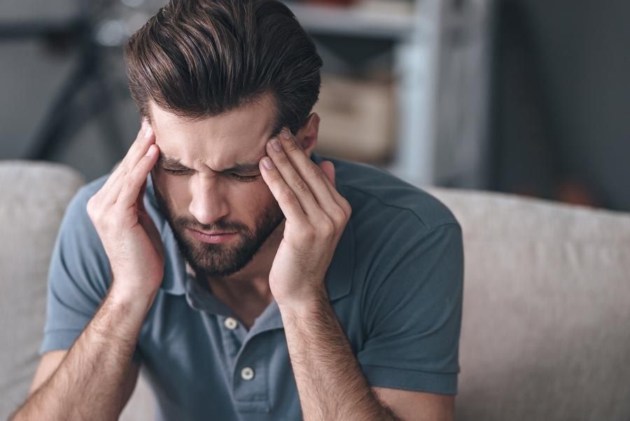 Man holds head in pain from migraine, seeks migraine treatment in Hoover AL