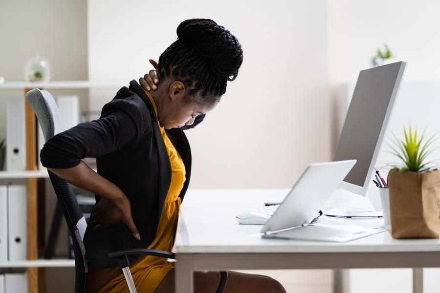 African American woman has back pain at her work desk