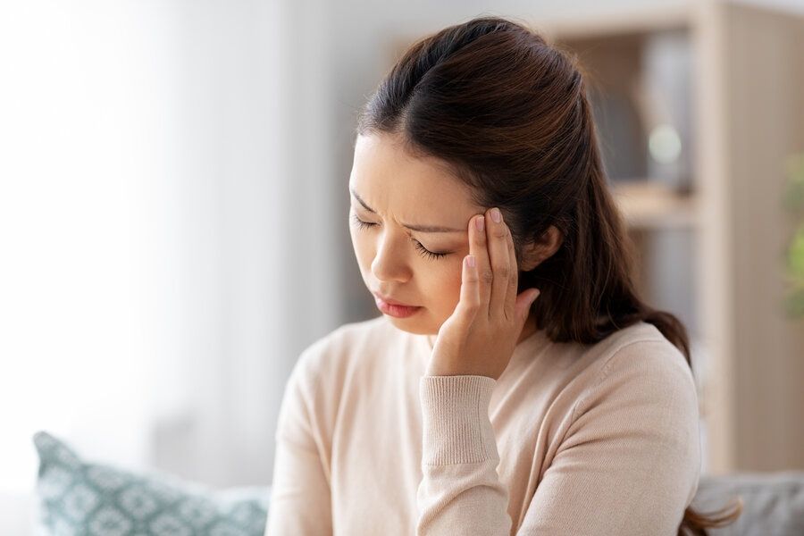 Asian woman suffers from migraine headache