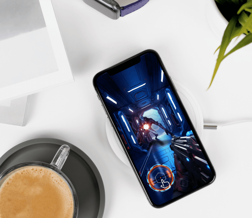 A smart phone next to a cup of coffee, the phone showing the Oblivion game