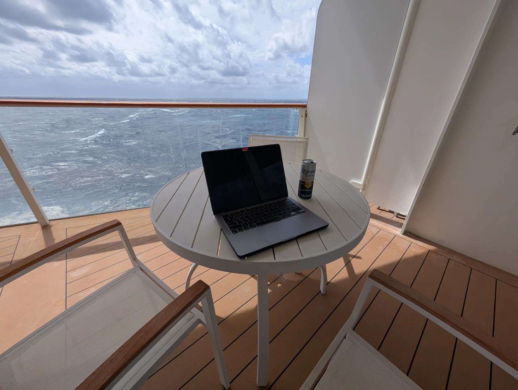 Laptop and a Corona on a balcony table aboard the Celebrity Silhouette, testing the ship's Wi-Fi speeds.