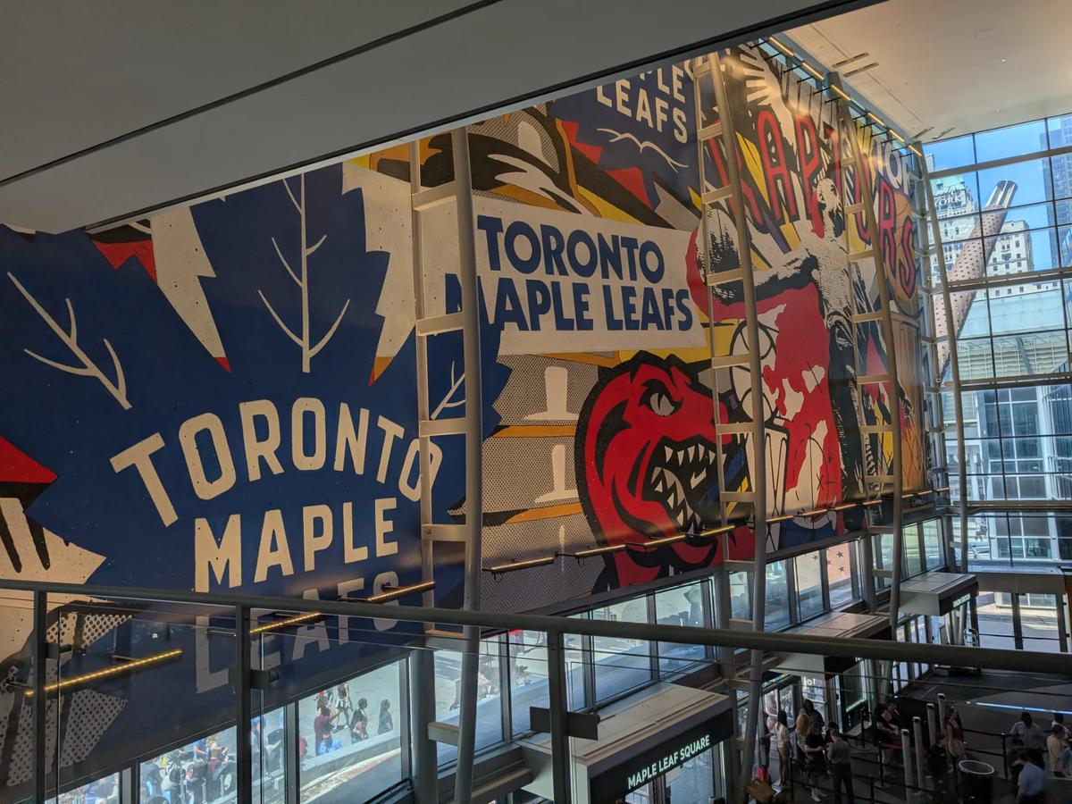 Large mural of the Toronto Maple Leafs and Raptors inside Scotiabank Arena, overlooking the street level.