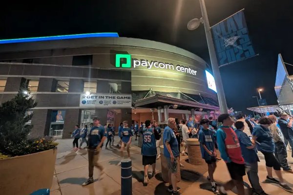 Fans walking into the Paycom Center in Oklahoma City for an OKC Thunder game at night.
