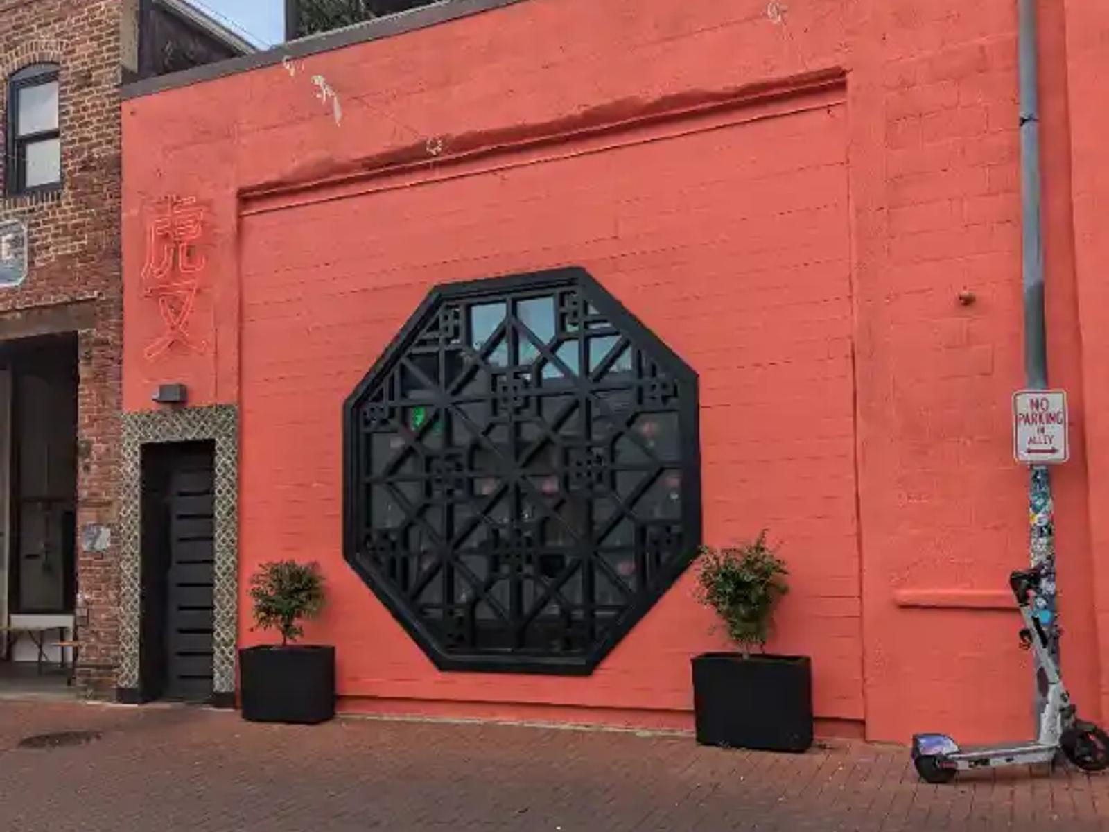 The distinctive octagonal window and neon sign at Tiger Fork in DC's Blagden Alley.