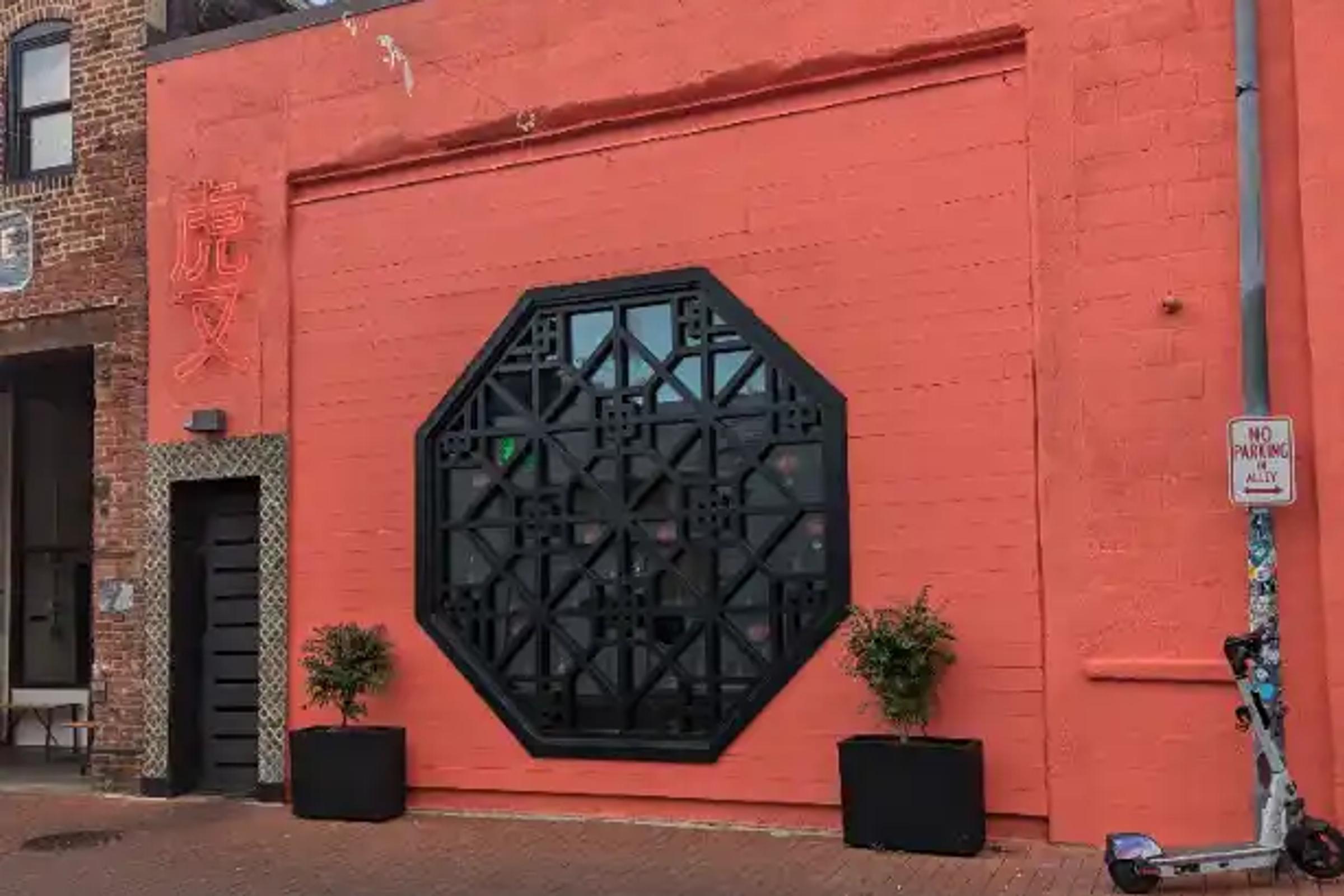The distinctive octagonal window and neon sign at Tiger Fork in DC's Blagden Alley.