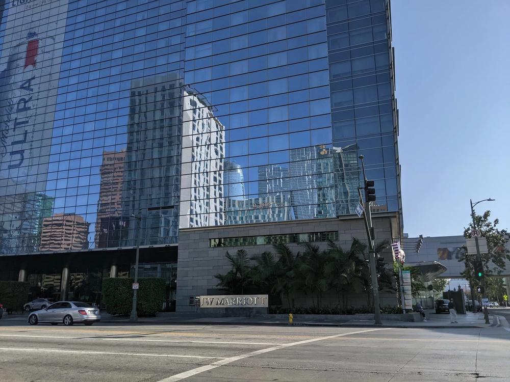Glass tower and entrance sign of the JW Marriott Los Angeles L.A. Live seen from the street in downtown LA.