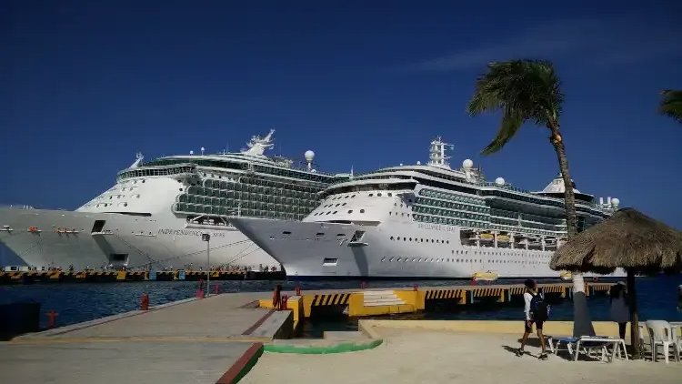 Independence of the Seas and Brilliance of the Seas docked at a pier under a clear blue sky.
