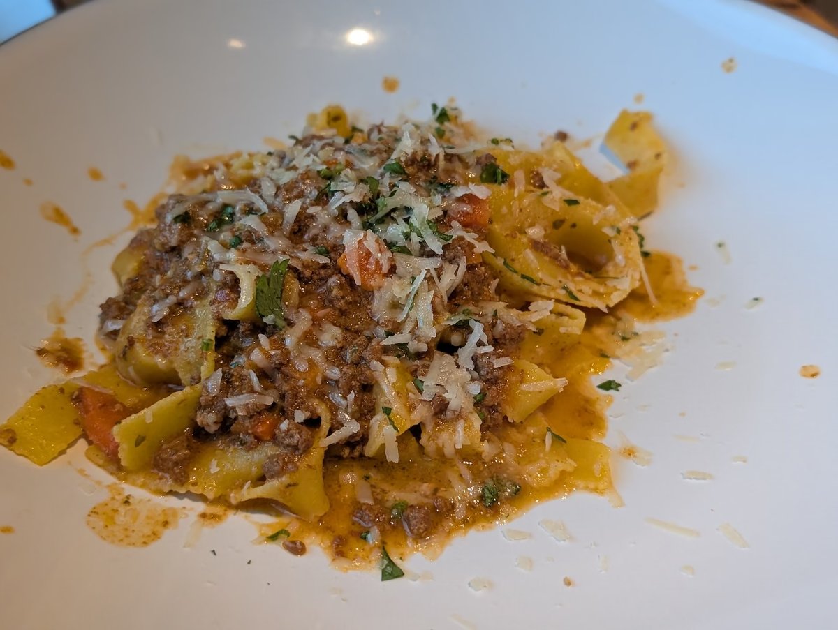 Handmade pasta Bolognese with grated cheese at Extra Virgin