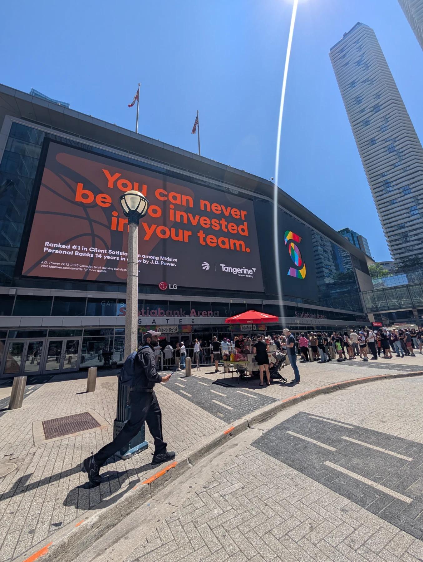 Outside Scotiabank Arena in Toronto. A big Tangerine ad on the wall and a long line of fans waiting at Gate 6.