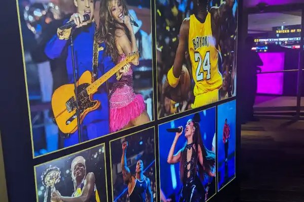 Wall of photos at Crypto.com Arena in LA, highlighting legendary Lakers moments and performers.
