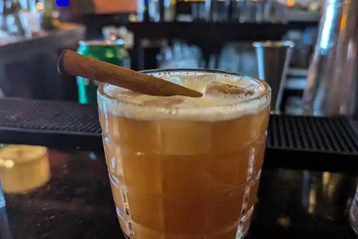 A cocktail garnished with a cinnamon stick at the bar at Tiger Fork in D.C.