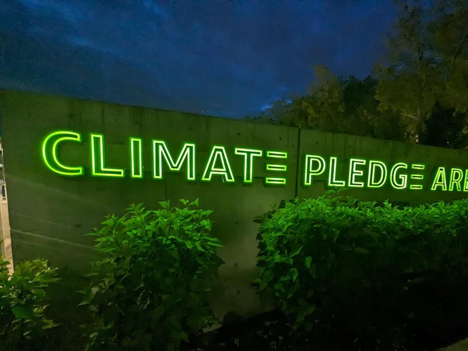 Glowing neon sign for Climate Pledge Arena in Seattle at night.