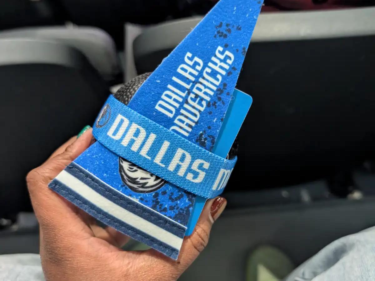 Holding a Dallas Mavericks pennant and souvenir wristband at the American Airlines Center.