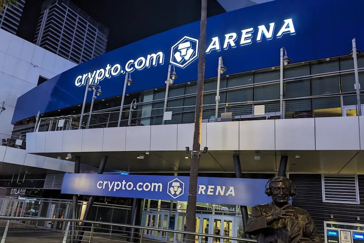 The bronze Chick Hearn statue outside Crypto.com Arena in Los Angeles at night.