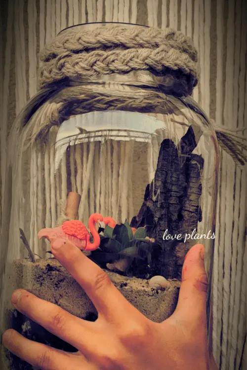 słoik z piaskiem i małym flamingiem