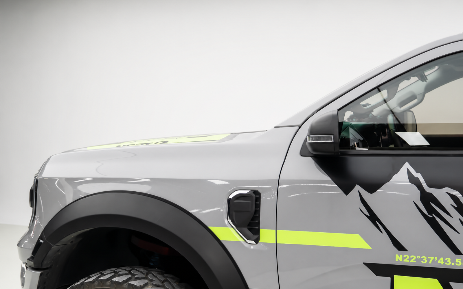 Bare pillar. Bumper lights sit in the dust the front tyres throw, so the beam lights the haze.