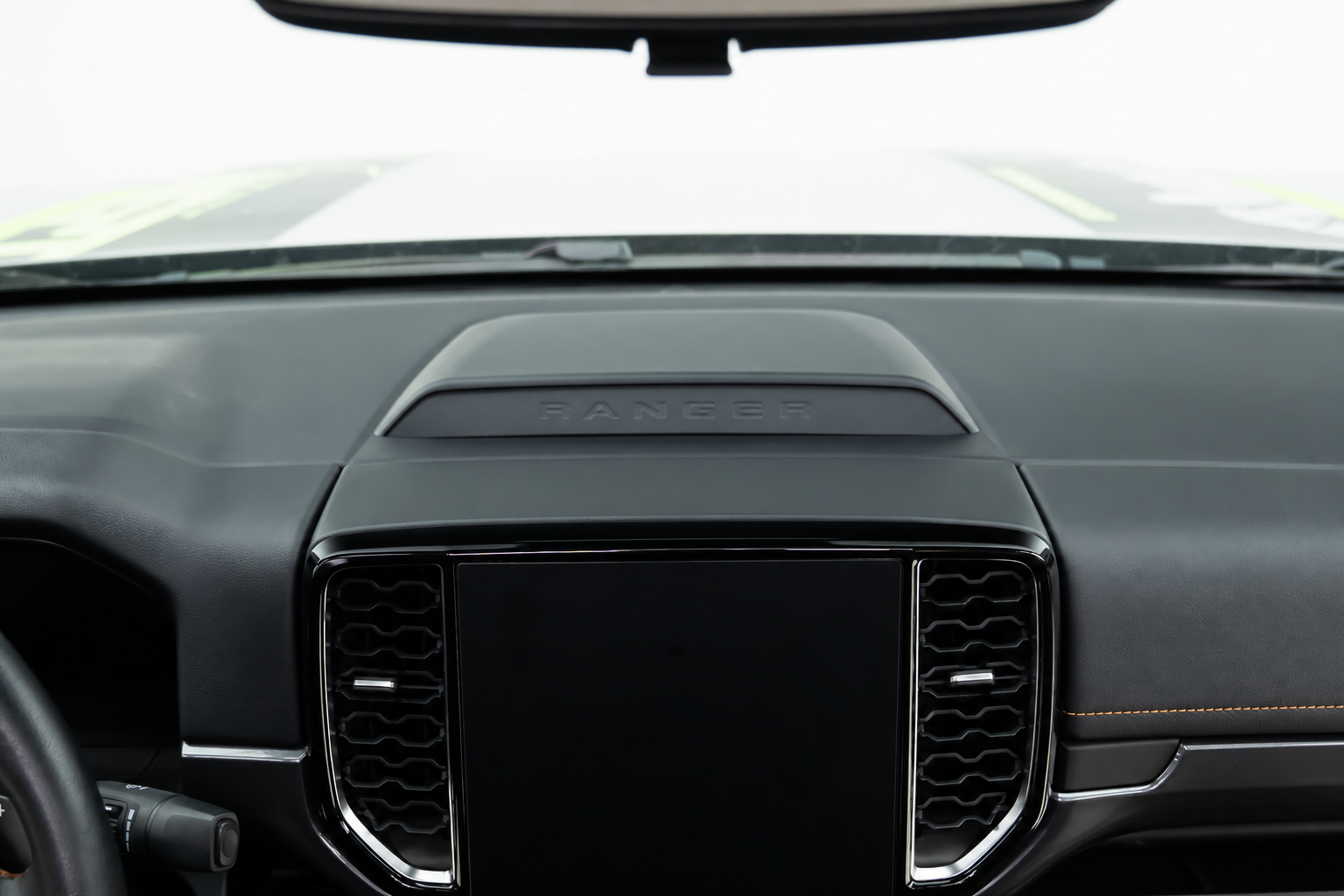 The screen fills the middle of the dash, so a phone ends up on a vent clip or stuck to the glass.