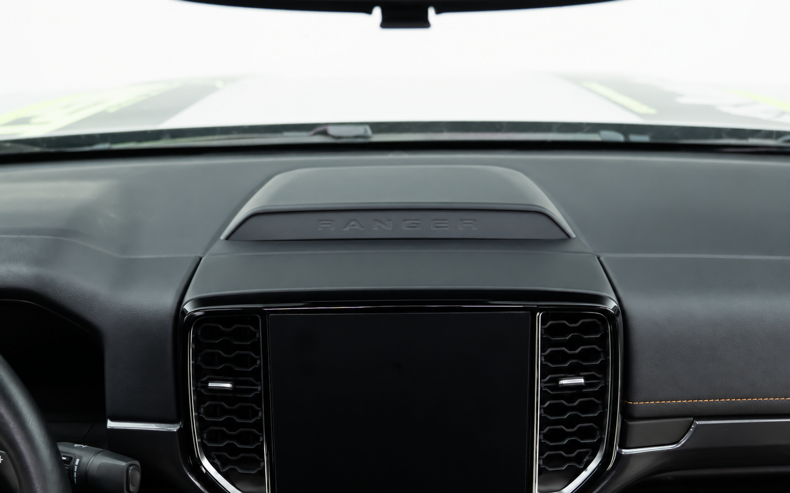 The screen fills the middle of the dash, so a phone ends up on a vent clip or stuck to the glass.