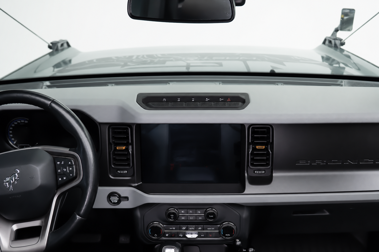Bare dash. Add a phone, then a camera, then a radio, and the cab fills with stick-on pads at odd angles.