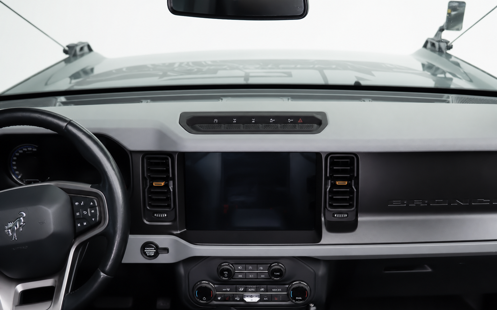 Bare dash. Add a phone, then a camera, then a radio, and the cab fills with stick-on pads at odd angles.