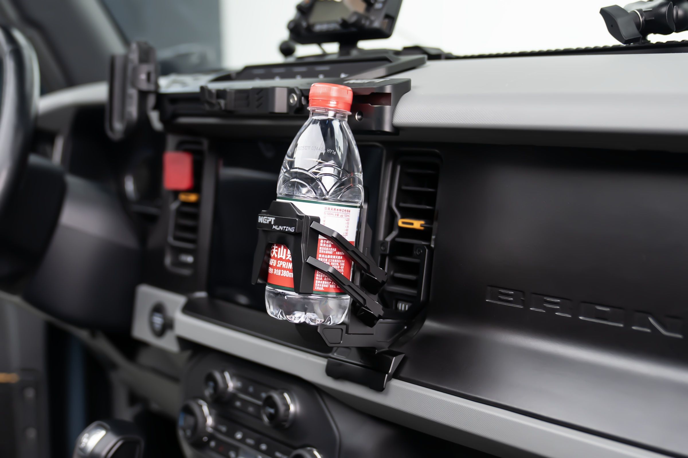 A holder up beside the screen. It grips whatever you put in it, not one size.