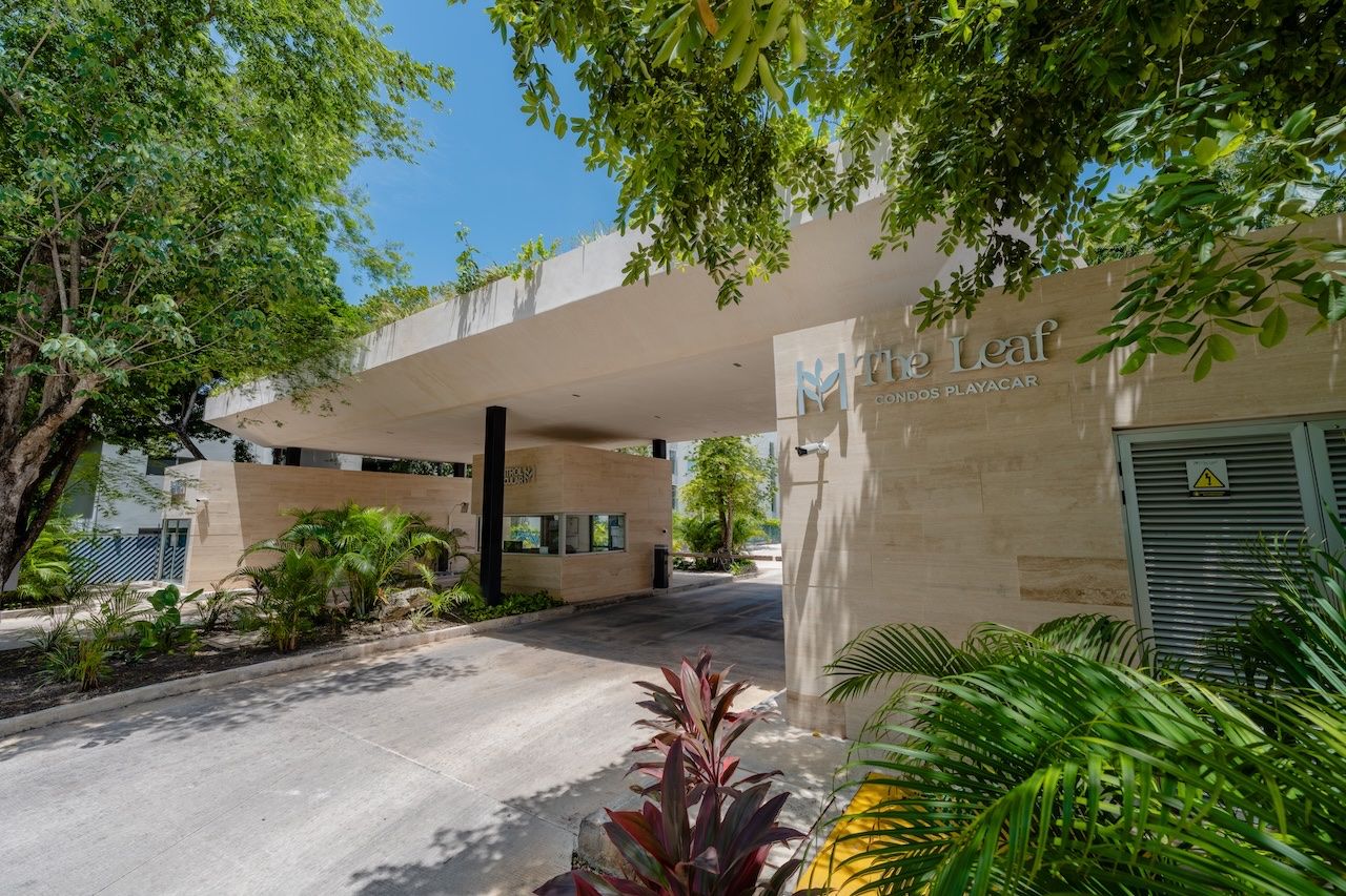 Entrance archway with The Leaf signage, framed by trees and tropical landscaping