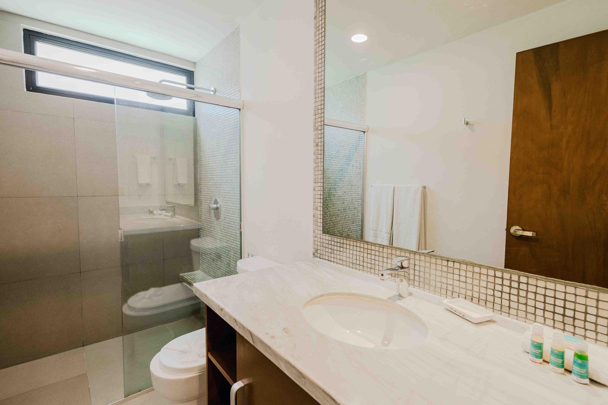 Bathroom with a vanity, mosaic-tile backsplash and a glass-enclosed shower at Lunada 314