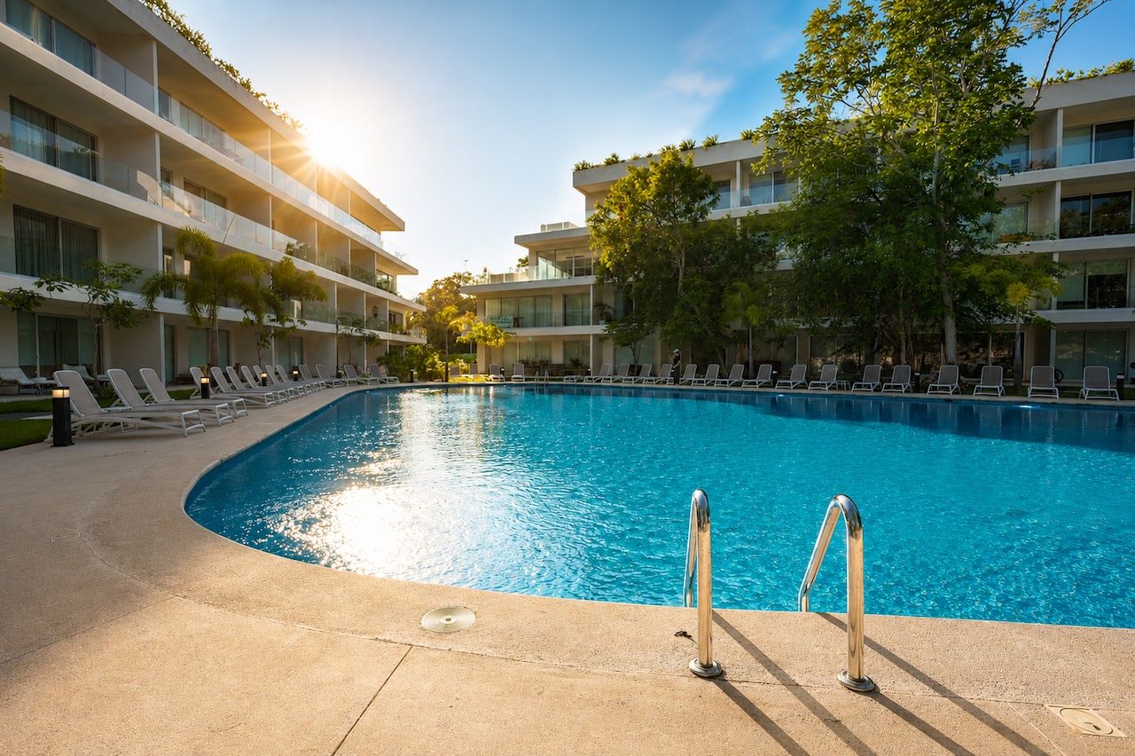 Community pool at sunset with golden light on the water at The Leaf