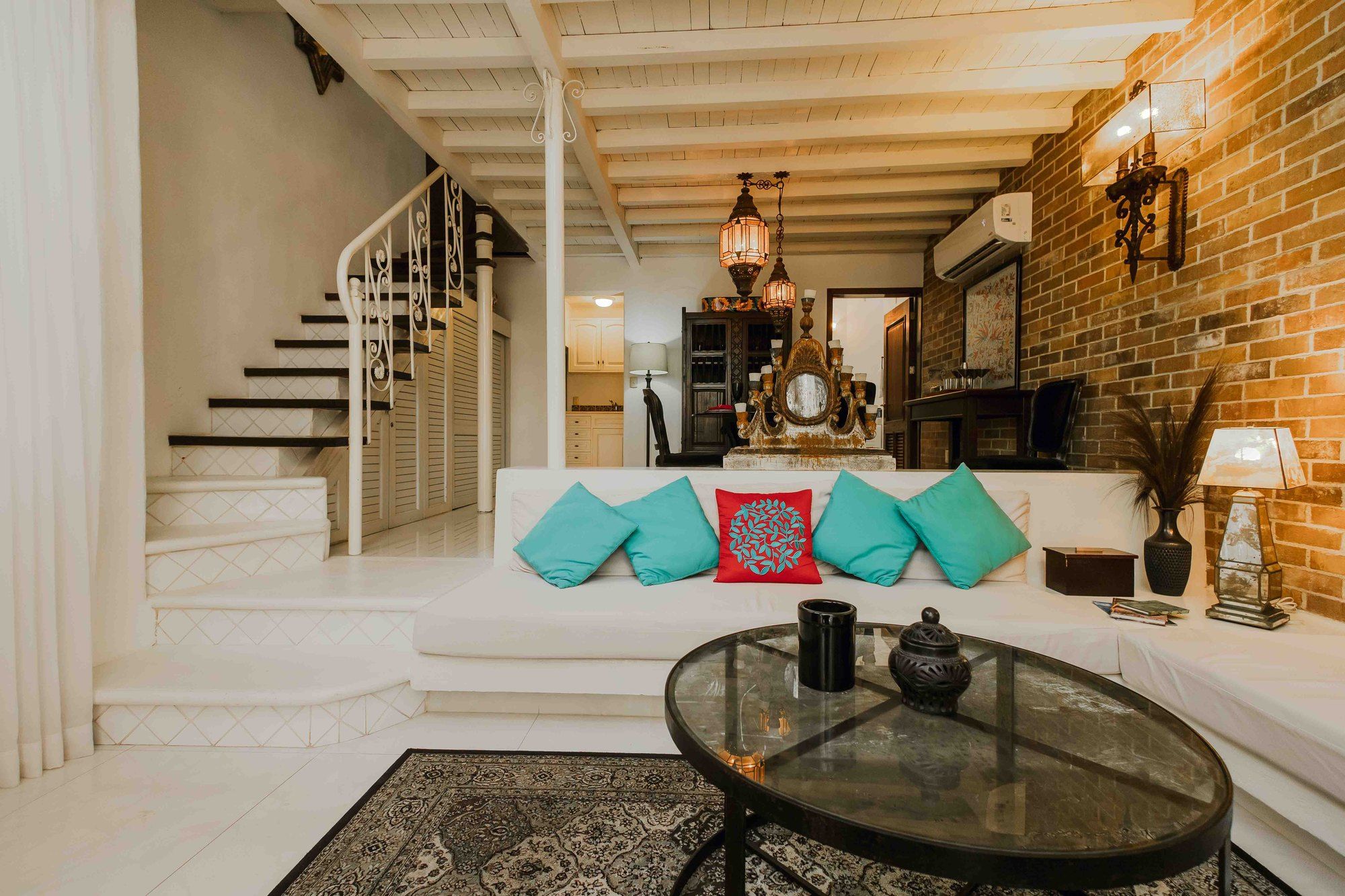 Living room with white sofas and a staircase leading to the loft bedroom