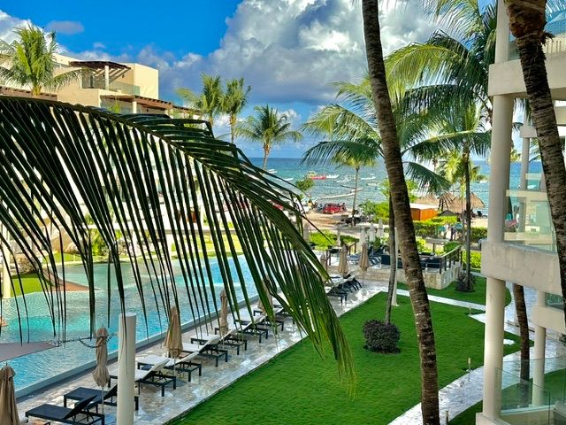 Balcony view over the resort pool and ocean at The Elements 205