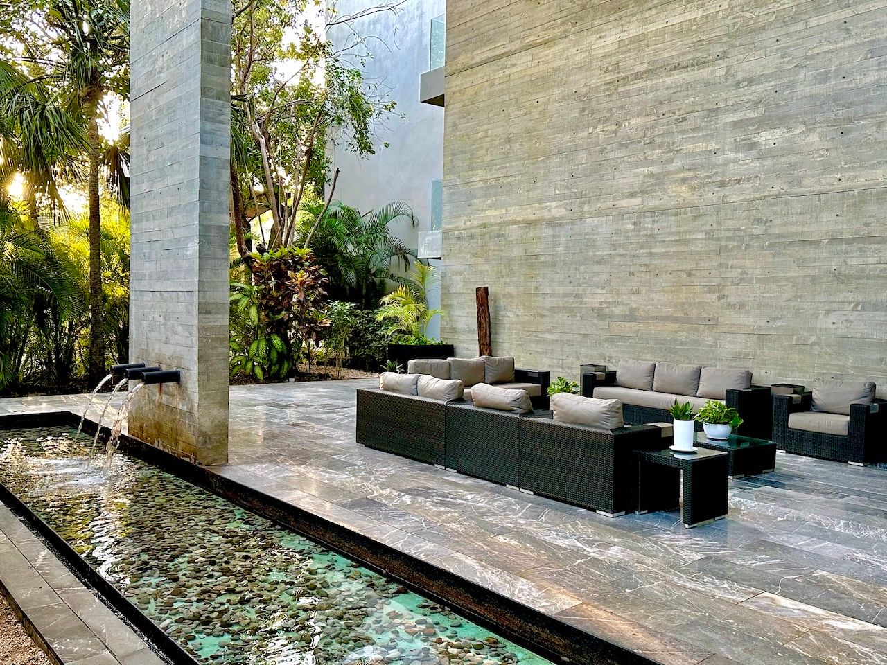 Common-area courtyard with a water feature and lounge seating at Vaivén del Mar, Playacar
