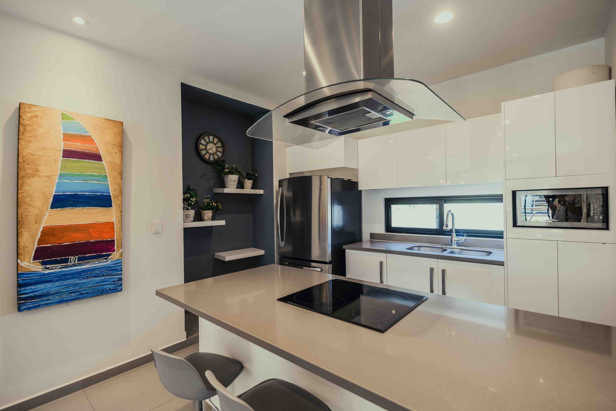 Kitchen with a central island, cooktop and a sail painting at Lunada 314