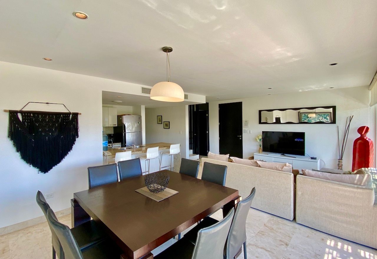 Living room with a sofa, television and dining table at The Elements PH21