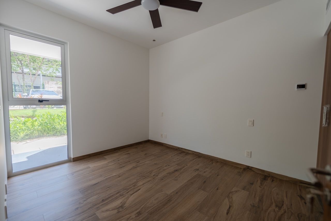Bedroom with a ceiling fan and a glass door to the outdoors at The Leaf