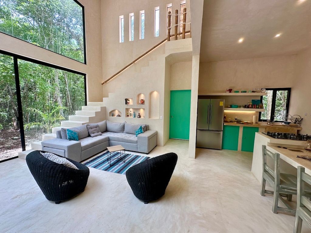 Double-height living room opening to the jungle at Casa Carlo