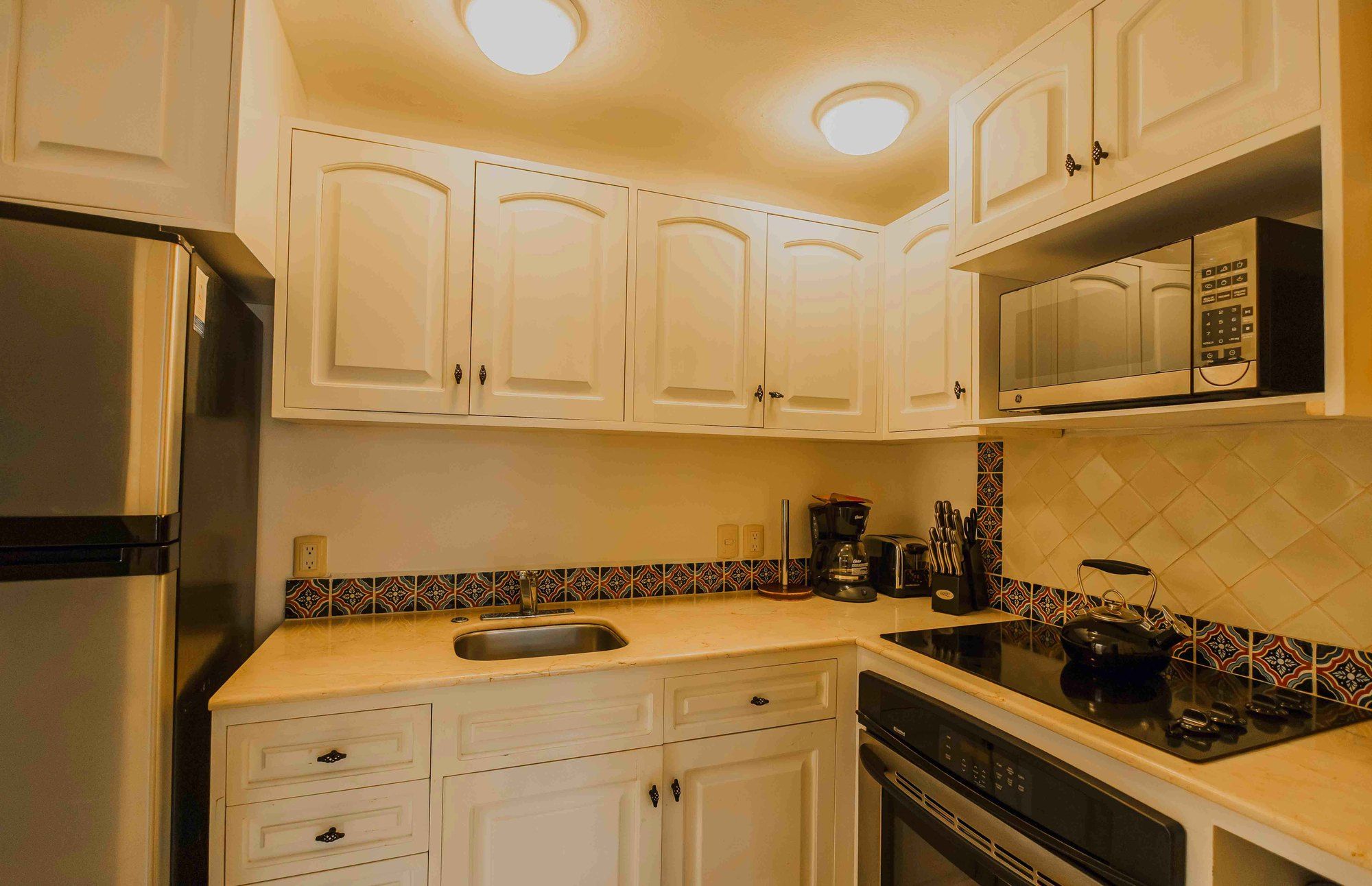 Kitchen with white cabinets, stove and microwave