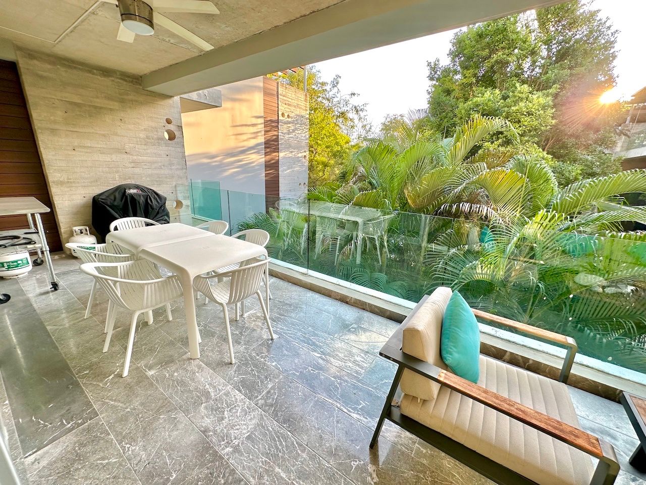 Private terrace lounge overlooking tropical vegetation at dusk at Vaivén del Mar