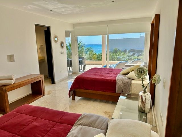 Bedroom with two beds and a window view of the ocean at The Elements PH21