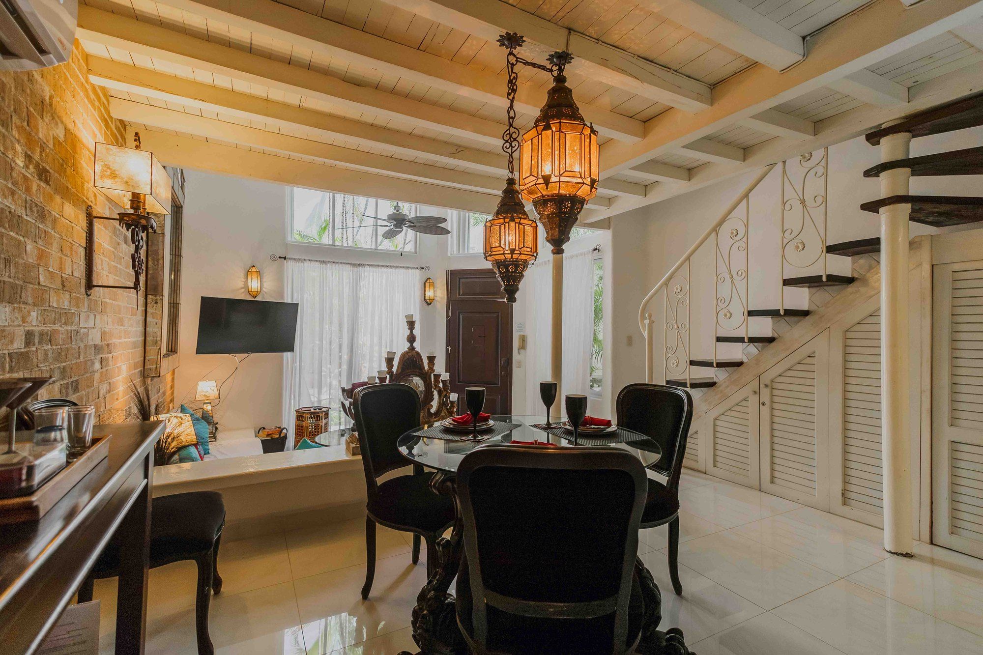 Dining area with hanging lights and a staircase to the loft