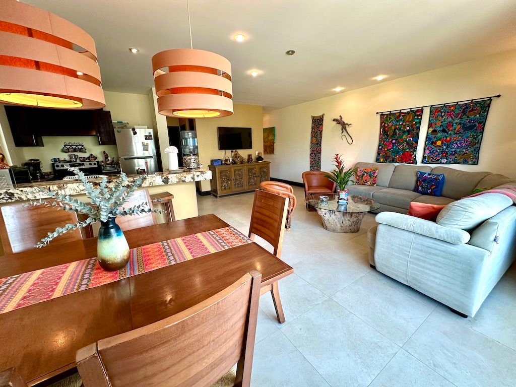 Living and dining area with embroidered wall textiles and a sculptural iguana accent at Pueblito Escondido