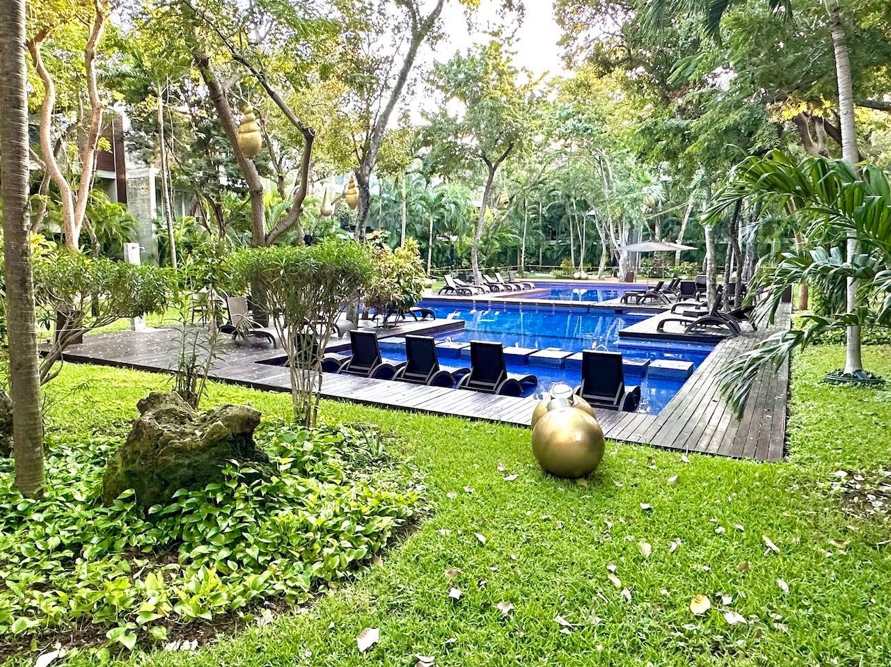 Oasis-style swimming pool surrounded by tropical landscaping at Vaivén del Mar, Playacar