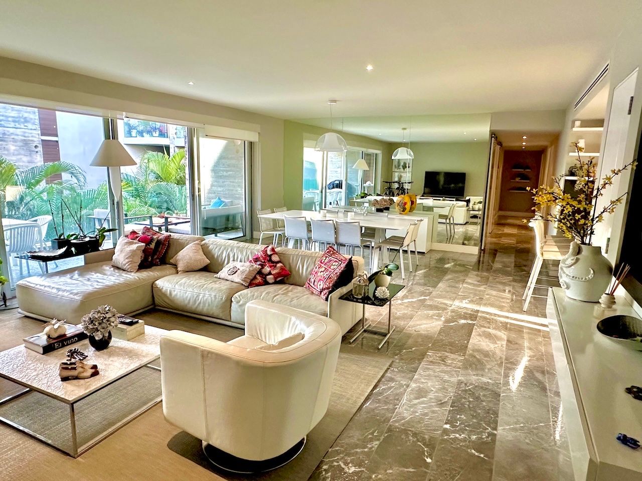 Open-plan living and dining room with a green accent wall opening onto the terrace at Vaivén del Mar