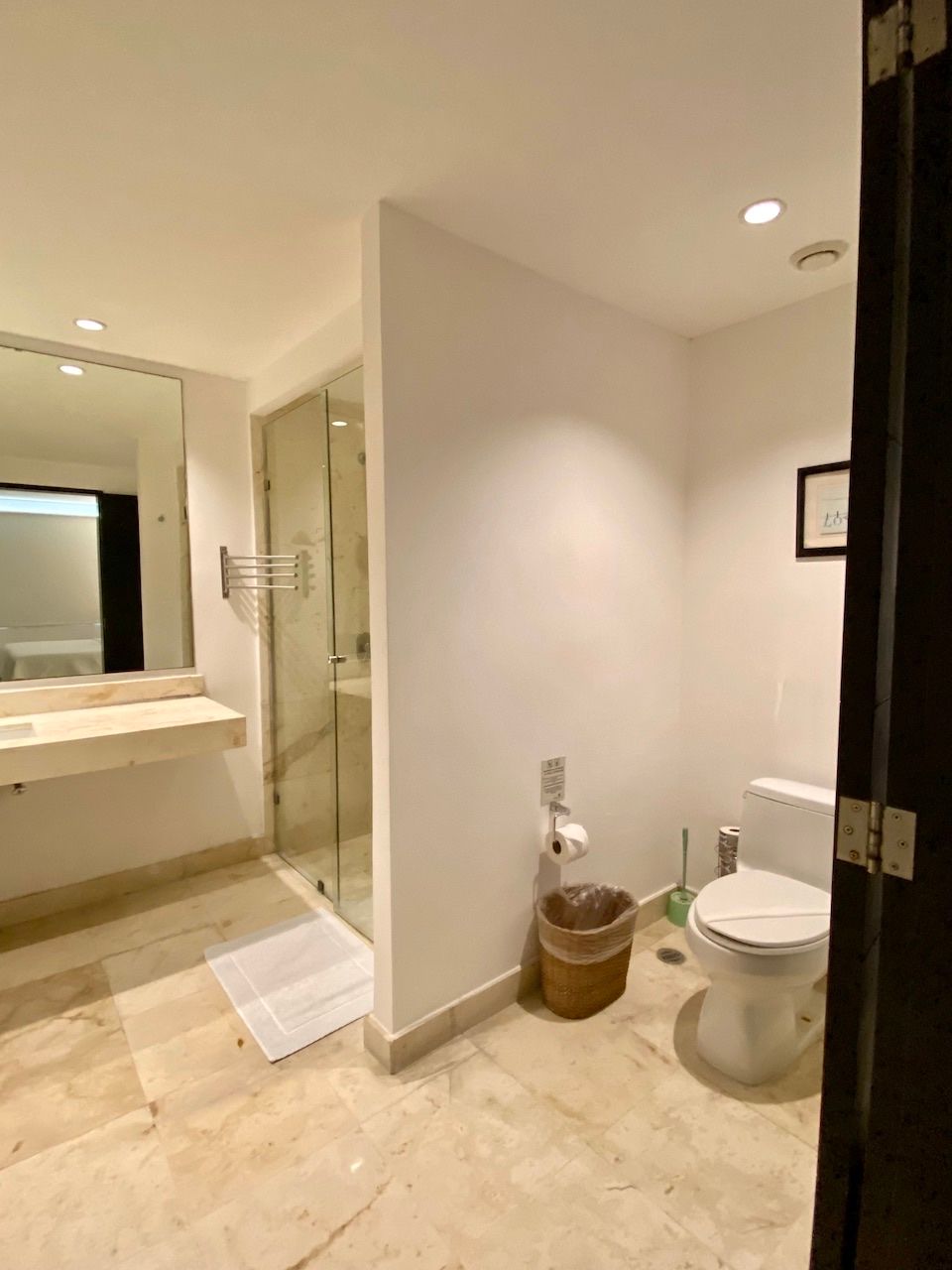 Bathroom with a glass shower enclosure, marble floor and toilet at The Elements PH21
