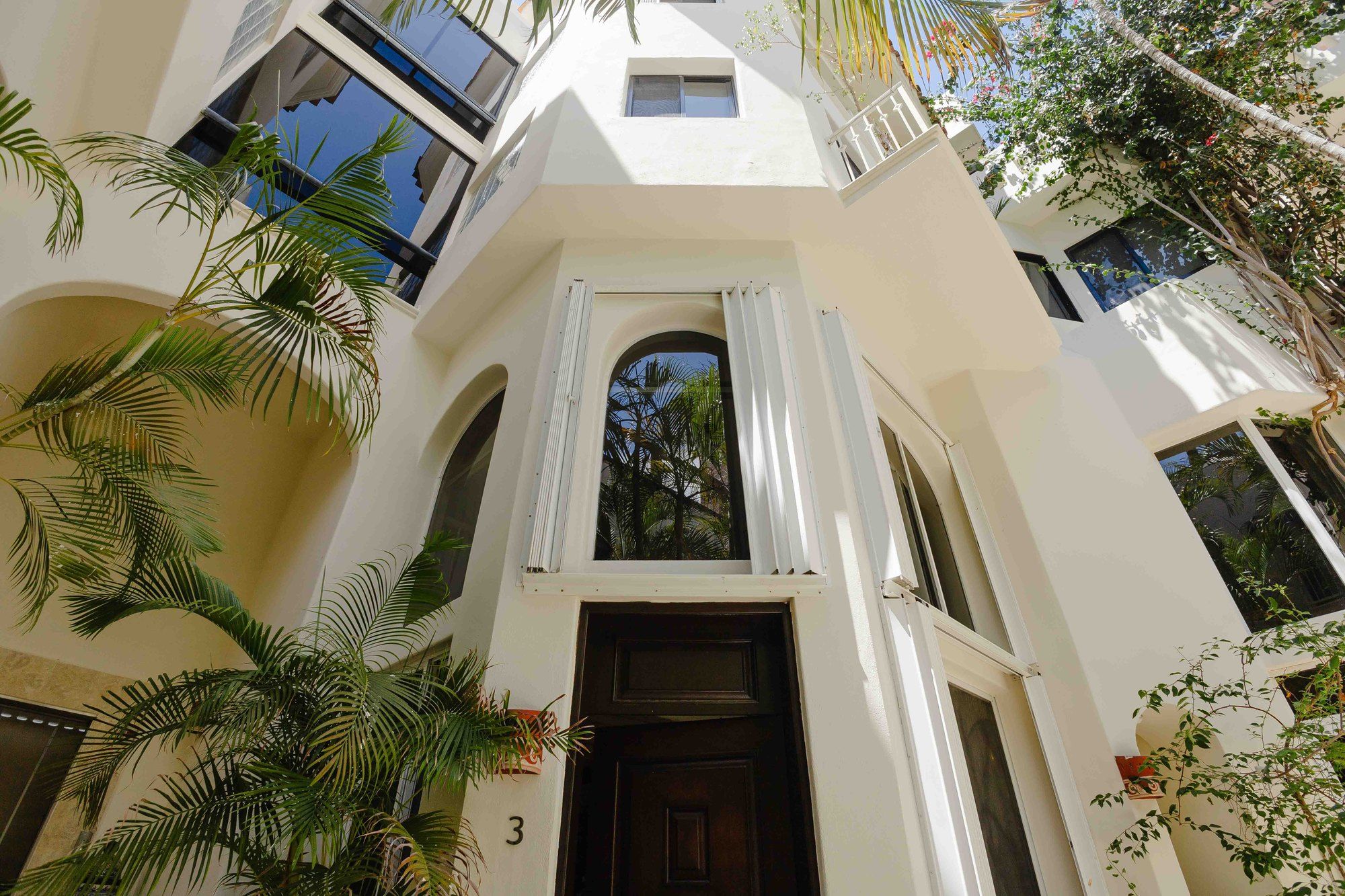 White facade and arched entrance at Royal Palms