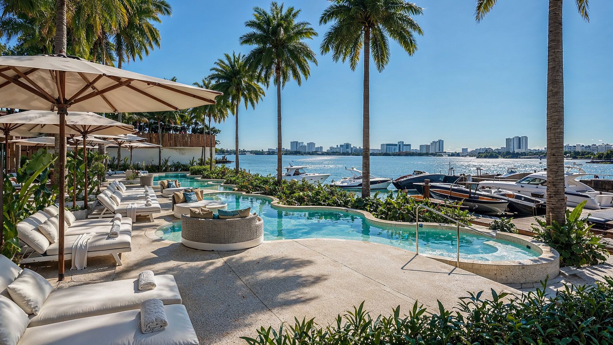 Architectural rendering of the pool deck and private marina slips with docked yachts at golden hour