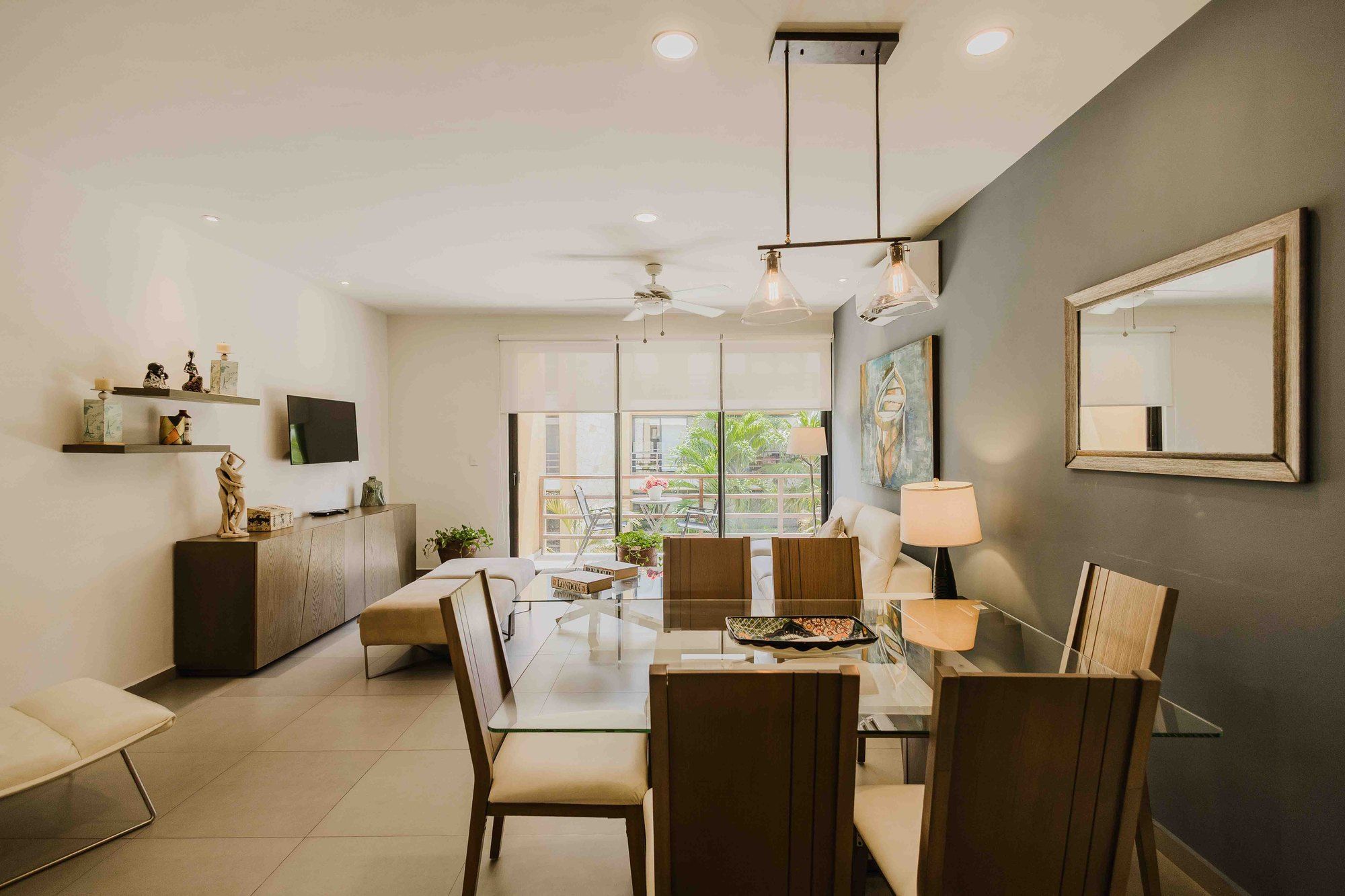 Living and dining area with a glass dining table and balcony doors at Lunada 314