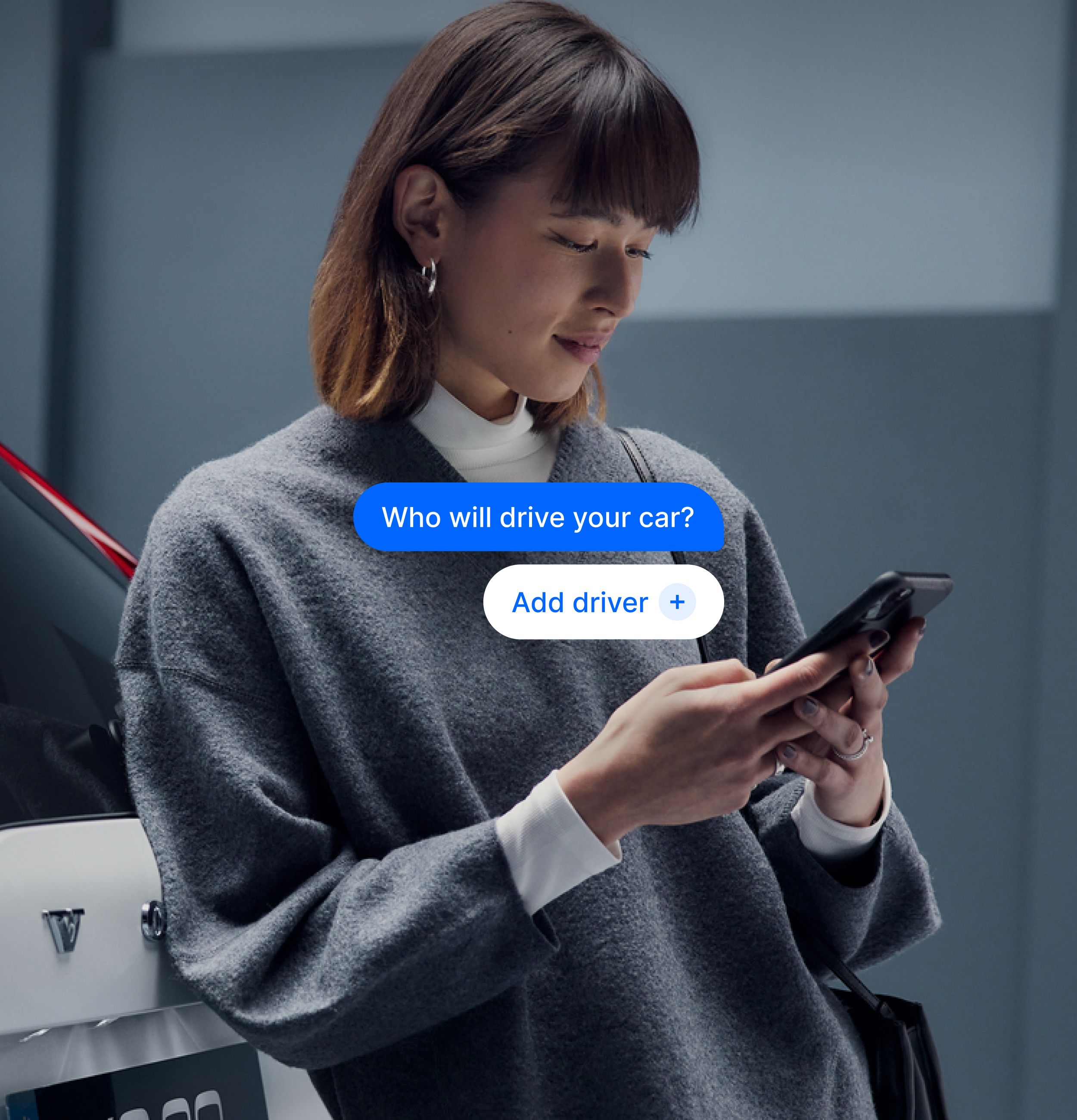 Person standing next to a car, using a smartphone, with an app interface asking, “Who will drive your car?”